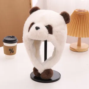 Detail der flauschigen Panda-Mütze mit Ohrenklappen aus weißem Kunstfell und Bommeln