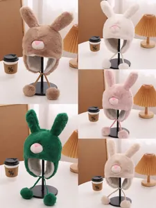 Detalle de gorros de peluche con orejas largas de conejo en varios colores y pompones