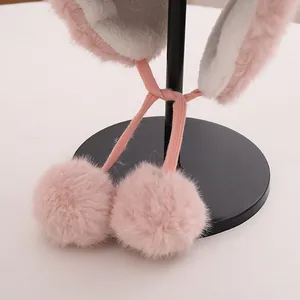 Detail der rosa Kunstfell-Fliegermütze mit Lammwollfutter und Bommel-Bändern