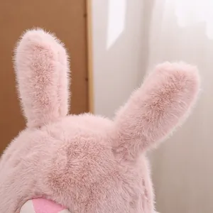 Detalle de felpa rosa con largas orejas de conejo en un gorro cálido para niños y niñas