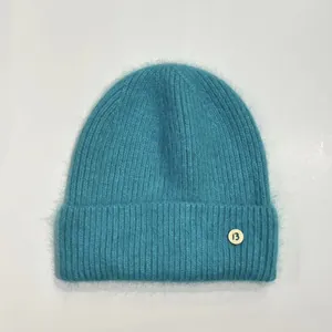 Detalle del gorro de punto de conejo azul con textura de canalé y el emblema 13