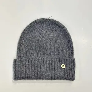 Primer plano del gorro de punto gris con textura de pelo de conejo y parche de letra B