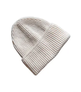 Primer plano de la textura de punto acanalado crema en un gorro de invierno doblado