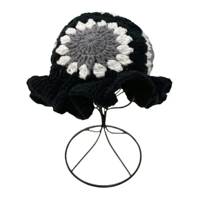 Handcrafted knit bucket hat with ruffled brim and floral pattern in black and white