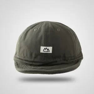 Detailed texture of olive green canvas docker cap with white brand logo woven label