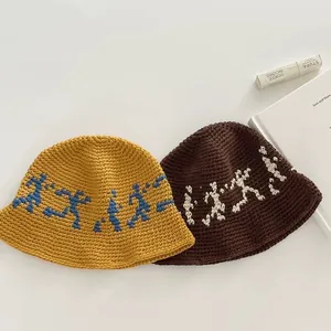Knitted bucket hats in yellow and brown with decorative stickman patterns