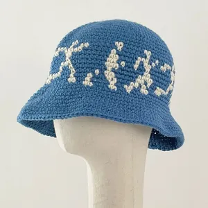 Handmade crochet knit bucket hat in blue with retro white letters on white mannequin