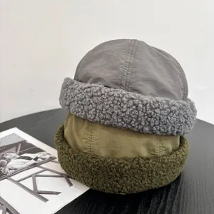 Stacked vintage docker caps with lamb wool trim in grey and olive green for winter