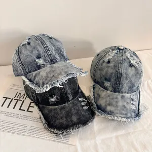 Detail of distressed denim baseball caps with frayed edges and vintage washed finish