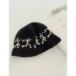 Detailed top view of a black knit bucket hat with white pattern and cozy texture