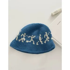 Detailed close-up of blue crochet bucket hat with white pattern and woven texture