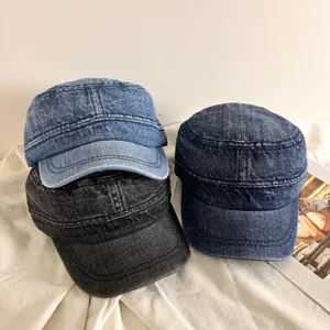 Vintage washed denim cadet caps in light blue, dark blue, and grey on white fabric