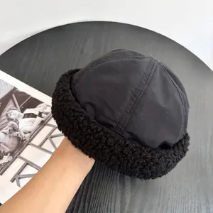 Close-up of black brimless docker hat with windproof fabric and warm faux lamb wool trim