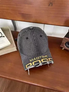 Close-up of vintage washed denim baseball cap with yellow embroidery and frayed brim detail