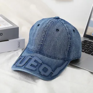 Deep blue denim baseball cap with UEO 3D embroidery on a minimalist textured setup