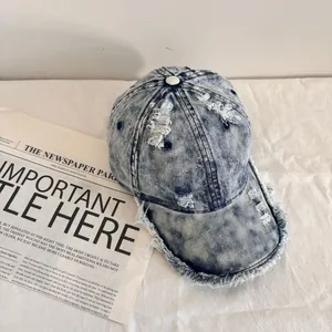 Distressed vintage light blue denim baseball cap with frayed edges and ripped detailing