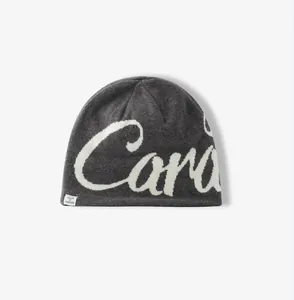 Detailed view of dark grey knitted beanie with white Cara jacquard pattern and logo tag