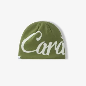 Detail of olive green knit beanie featuring white cursive Cara jacquard and woven tag label