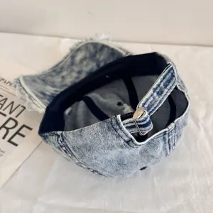 Detail shot of frayed edges and snowflake wash texture on a denim baseball cap