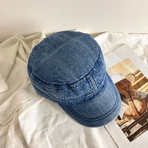 Detailed close-up of dark blue washed denim fabric and reinforced stitching on a cadet cap