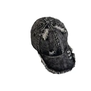 Distressed black washed denim baseball cap with frayed edges and vintage streetwear style