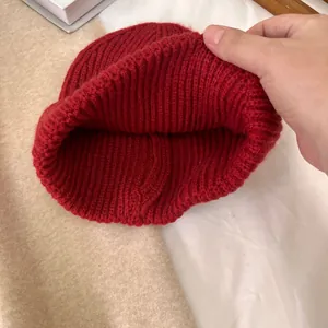 Detalle del gorro de punto acanalado rojo que muestra el tejido grueso y la costura