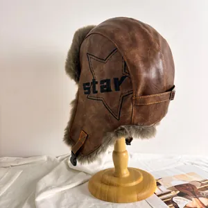 Détail du bonnet aviateur marron avec doublure en peluche et broderie sur le côté