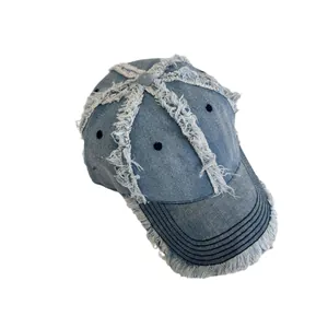 Distressed vintage denim baseball cap with frayed edges and retro street style