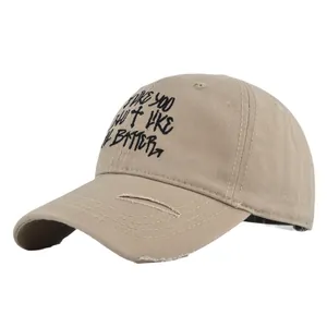 Distressed khaki baseball cap with cross embroidery and black graffiti lettering style
