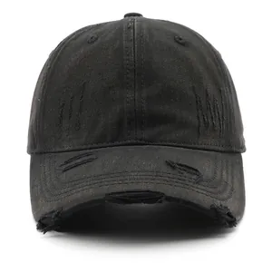 Close-up of distressed black denim baseball cap with vintage ripped details and cotton texture