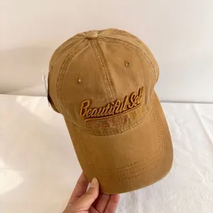 Close-up of brown washed cotton baseball cap featuring 3D Beautiful Self embroidery