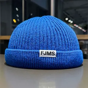 Detailed close-up of vibrant royal blue knit docker hat with FJMS woven label