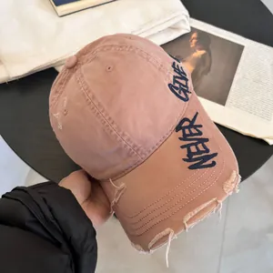 Detalle de gorra rosa efecto desgastado con bordado Never Give Up en azul marino