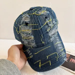 Distressed blue washed denim baseball cap with yellow stitching and vintage street style
