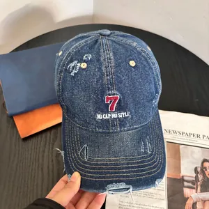 Close-up of vintage blue denim baseball cap with red number 7 embroidery and distressed details
