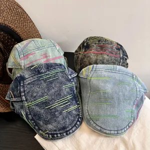 Detailed top view of vintage denim ivy caps featuring colorful contrast stitching and washed textures
