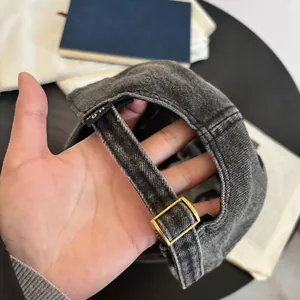Detalle de la gorra de béisbol de mezclilla lavada con hebilla de metal y etiqueta bordada