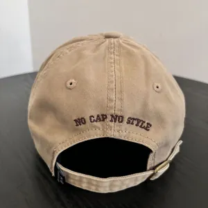 Detail of khaki cotton baseball cap back with brown embroidered NO CAP NO STYLE text