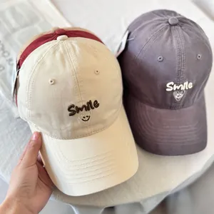 Three cotton baseball caps with Smile face embroidery in beige, grey and red colors