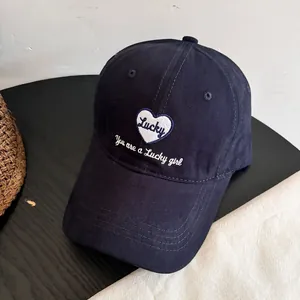 Detalle de gorra azul marino con bordado de corazón Lucky y costuras en la visera