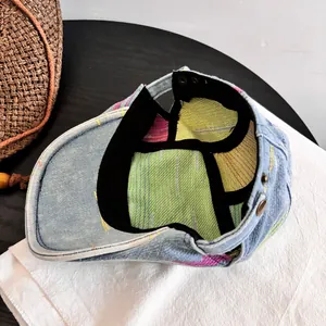 Detail of denim beret featuring colorful striped lining and black sweatband inside