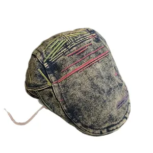 Faded blue denim flat cap featuring colorful decorative stitching and retro washed style