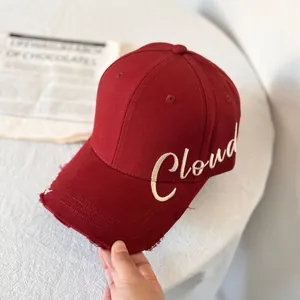 Detalle de la gorra de béisbol granate con bordado Cloud y borde de visera deshilachado