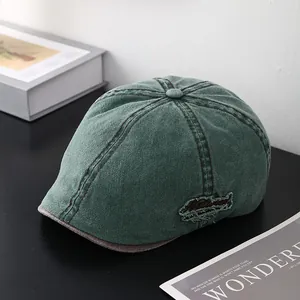 Béret vintage en coton lavé vert foncé avec broderie sur un fond minimaliste