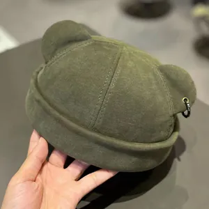 Detail of olive green docker hat featuring cute 3D bear ears and a black metal ring accent