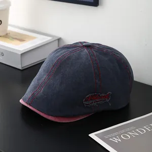 Détail d'une casquette en denim bleu avec coutures rouges et étiquette Natural