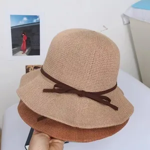 Japanese straw bucket hat with bow accent and wavy brim for summer sun protection