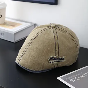 Détail de la casquette plate vintage kaki avec broderie Natural sur une table rustique