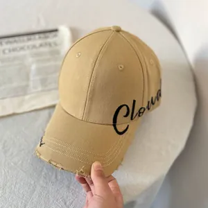 Primer plano de gorra de algodón caqui con bordado Cloud y visera con efecto desgastado