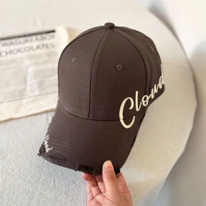 Detalle de la gorra de béisbol marrón oscuro desgastada con bordado de Cloud